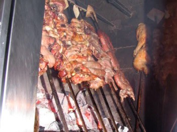 Figura 3 – L’ultima fase della cottura della carne in fornello, posta in verticale accanto al braciere acceso per favorire la doratura esterna. Fonte: braceria Caramia, Locorotondo (BA).